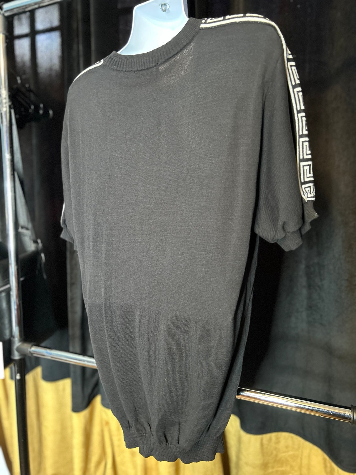 Original back photo showing the shoulder and sleeve trim on the black knit top